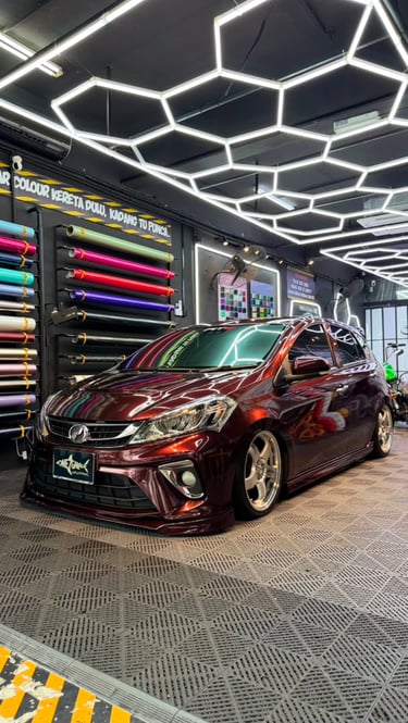 Perodua Myvi wrapped in gloss maroon vinyl with gold rims