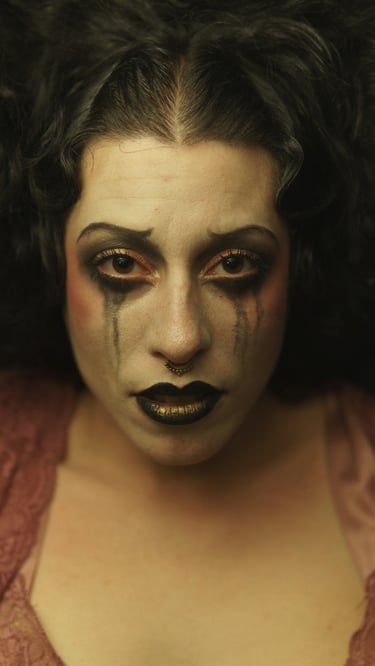 a woman with black makeup and makeup dropping on her face