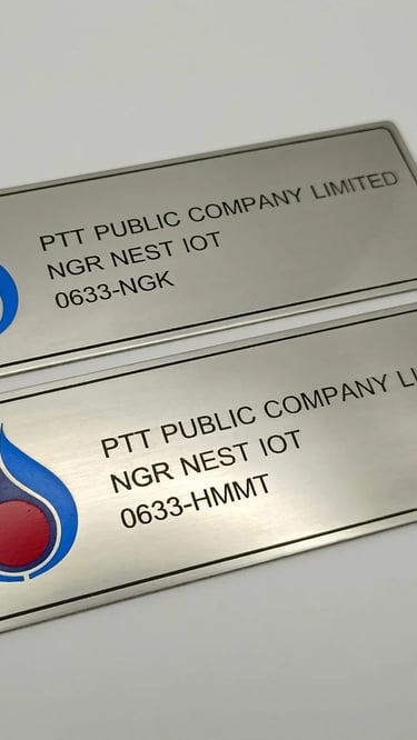 Custom engraved stainless steel metal nameplates with the PTT Public Company Limited logo and text.