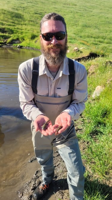 Geoff Cline with two California tiger salamander larvae at a conservation site in Madera County, CA.