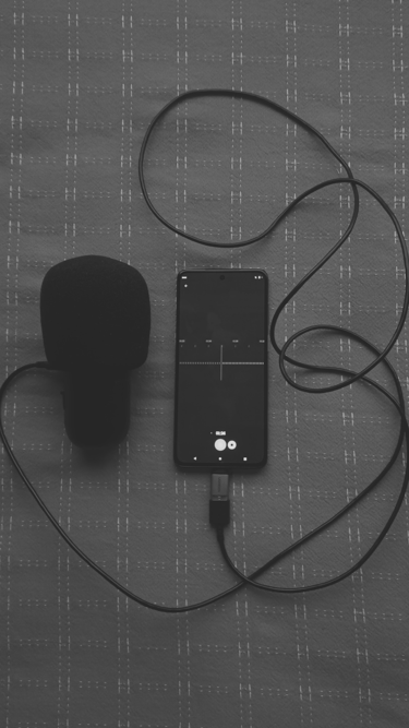 Micrófono oscuro conectado a un celular grabando un audio
