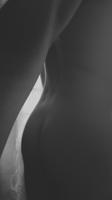 Fotografía artística en blanco y negro de la espalda y curvas de un cuerpo masculino.
