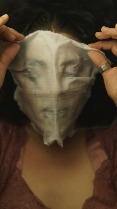 a woman with a mask covering her face with with a pieace of white fabric