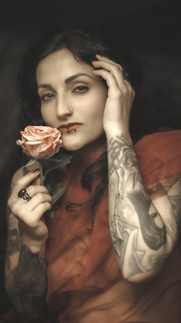portrait of a woman with tattoos on her arm and a rose