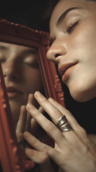 a woman with her eyes closed holding red miror