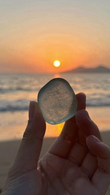 Close-up of a tarnish-free rhodium necklace shimmering softly in natural sunlight on a sandy beach background.