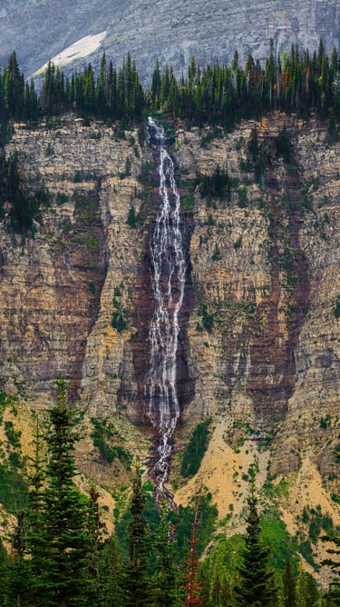 Crypt Falls cascading down a tall cliff in Waterton Lakes National Park, Alberta.