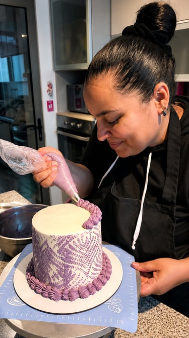 Un pastelero decora meticulosamente un pastel blanco de varios pisos con intrincados diseños de glas