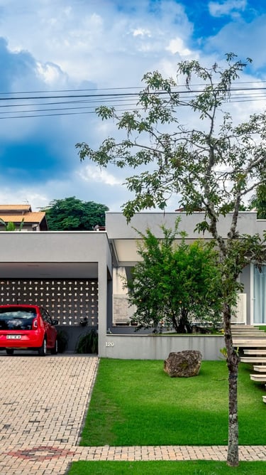 fachada cinza de casa contemporânea e carro vermelho