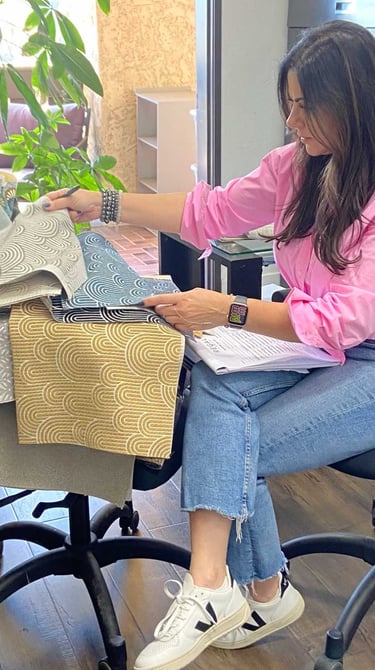 Sigal, founder of Solo Home Decor, selects fabrics while designing custom furniture.