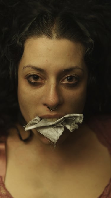 a woman with a with a pieace of white fabric in her mouth