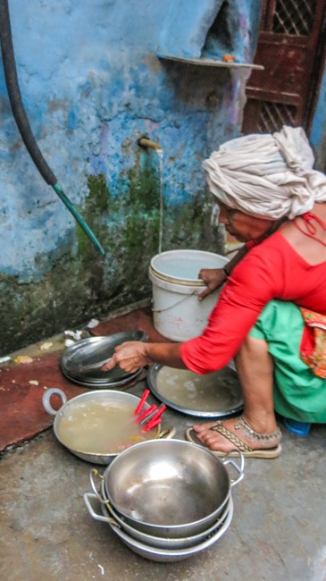 Woman cooking outside Delhi slum home