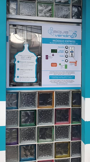 Aqua Vending water refill station machine built into a wall of decorative glass blocks.