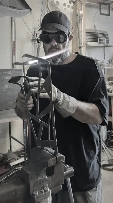 mikacreations dans son atelier en train de souder au chalumeau une sculpture bronze avec ses epi de protections