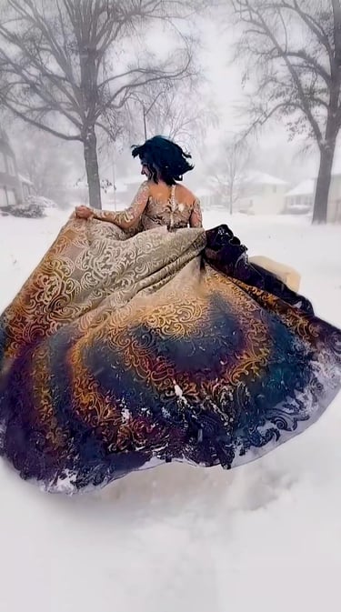 Bride running through a snow storm in a magical gold and blue wedding dress.