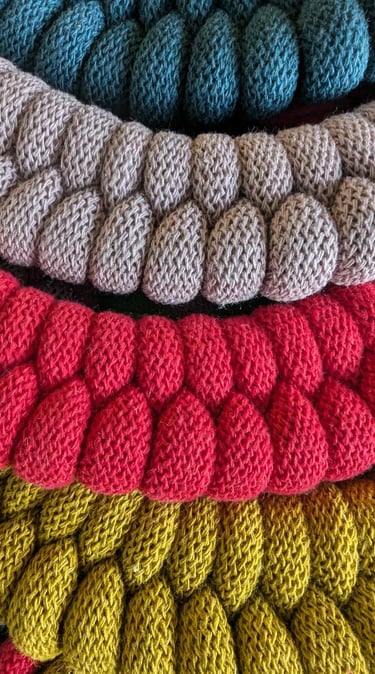 a pile of knitted yarn yarns and yarn