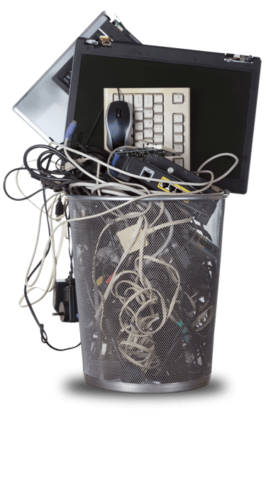 Metal trash bin filled with electronic waste, including a laptop, computer keyboard, and tangled cables.