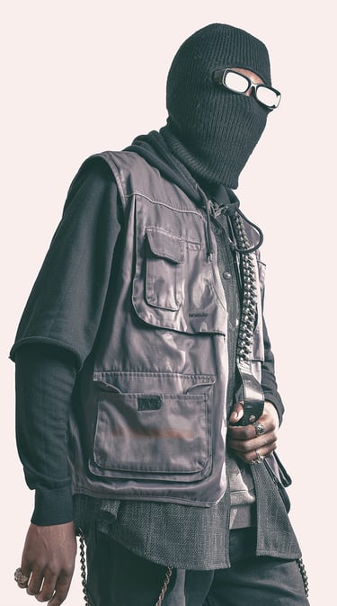 a man in a black jacket and a mask on posing for a photo