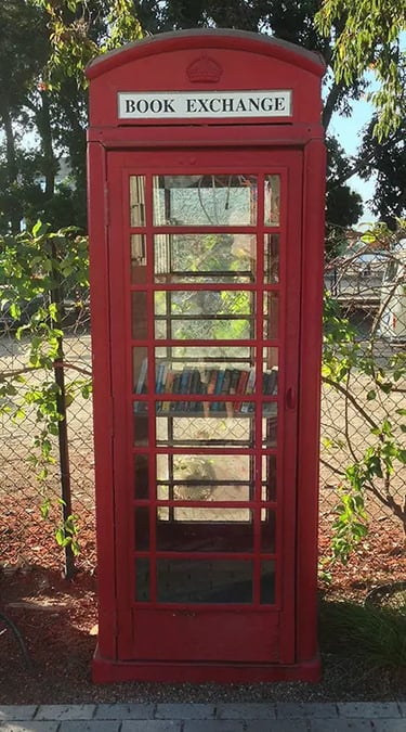 Red telephone booth converted into a public book exchange library.
