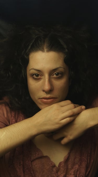 a woman with curly hair and a pink shirt