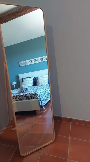 Vue sur une chambre abev literie moderne et dans les tons bleus