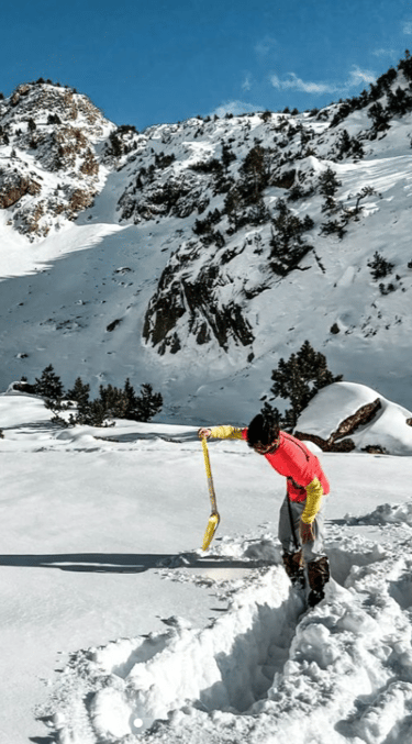 hombre clavando pala en la nieve