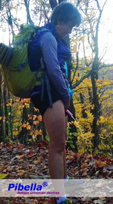 Woman with a backpack using the Pibella Urinella while standing, trousers pulled up and bottom covered.