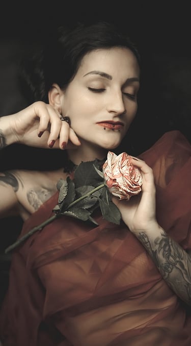 portrait of a woman with tattoos on her arm and a rose