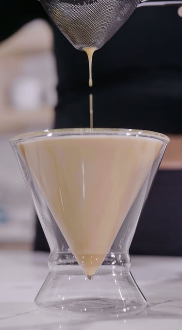 a person pouring a liquid into a glass bowl