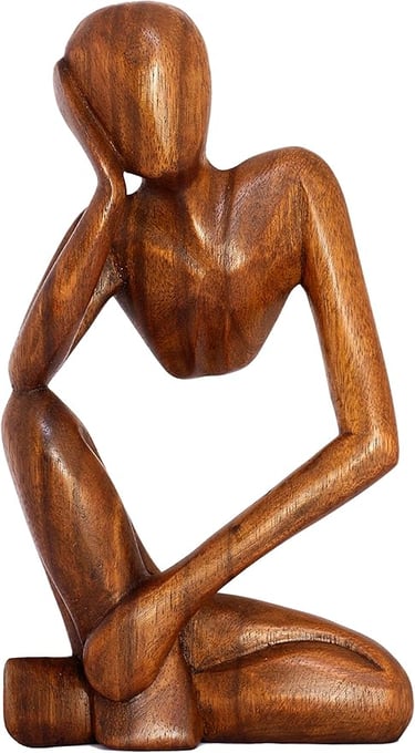 a wooden sculpture of a man sitting on a wooden table