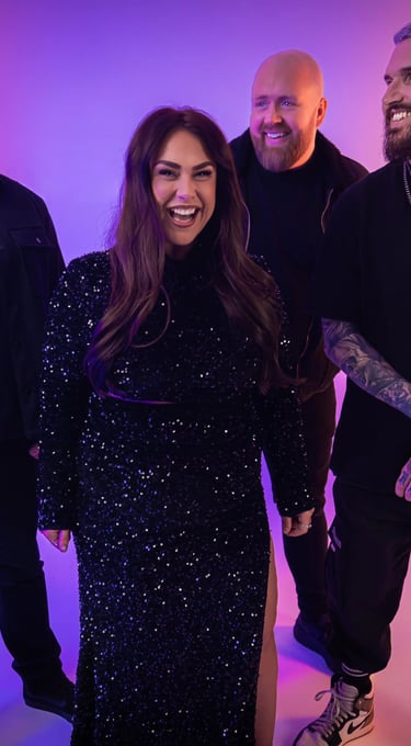 a group of people standing around a woman in a black dress