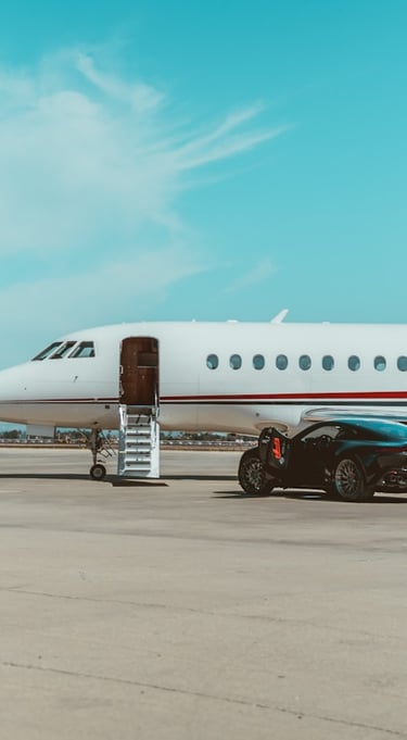 A private jet on the tarmac. Steps lead up to the door. A black sportscar is beside the jet.