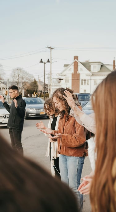 people standing in a parking lot praying