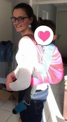 femme souriante portant son bébé sur le dos