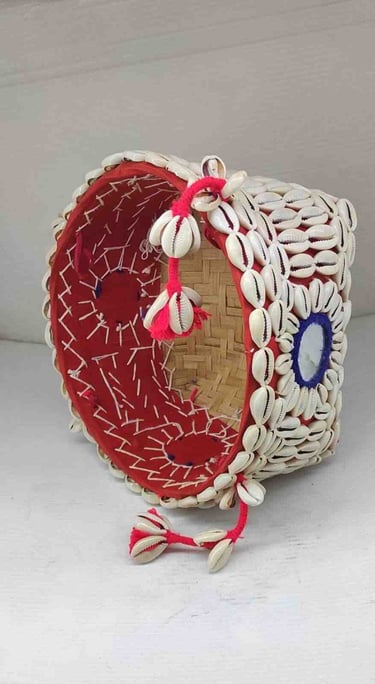 "Bamboo basket wrapped in red fabric with shell accents and floral garland–Designed for export