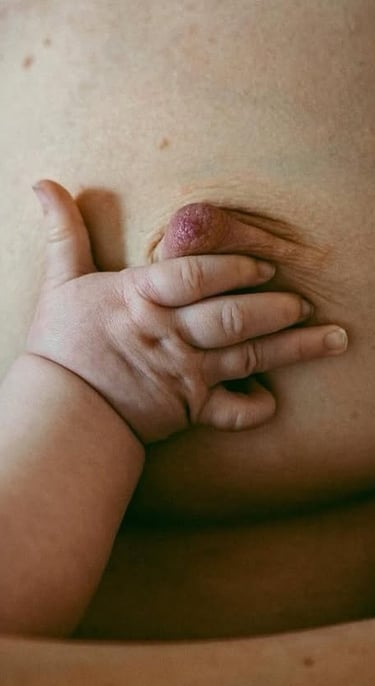 main de bébé sur un sein