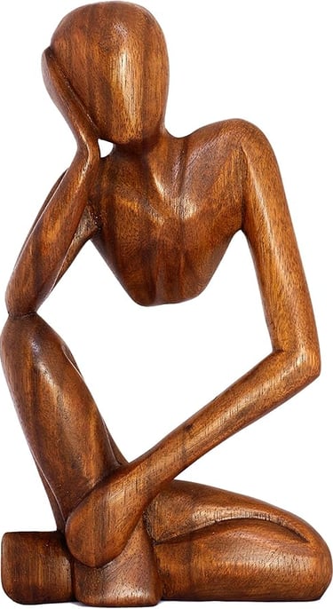 a wooden sculpture of a man sitting on a wooden table
