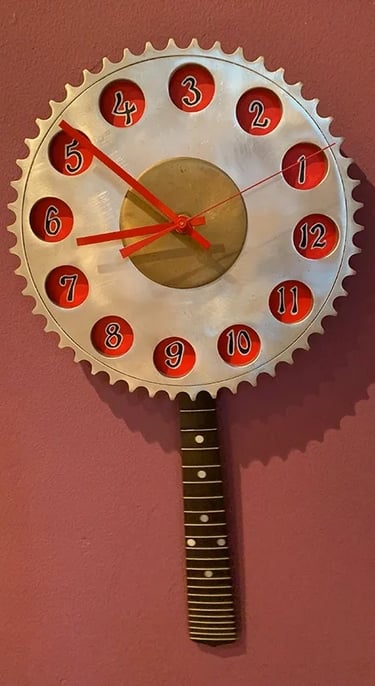 Clock made from aluminum gear with pendulum made from mandolin fretboard.