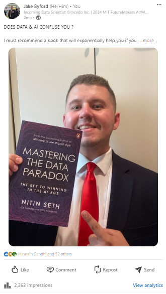 Jake Byford in a suit and tie holding a book titled MAstering the Data Paradox by Nitin Seth
