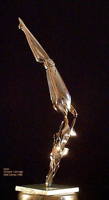 a chrome plated steel sculpture of a futuristic woman diving into a pedestal