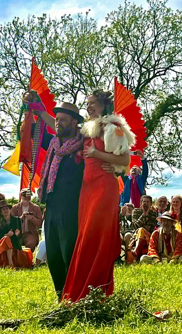 large outdoor spring handfasting ceremony of royal orange and navy blues, yellows and golds.