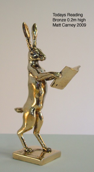 a golden rabbit statue of a rabbit with a book