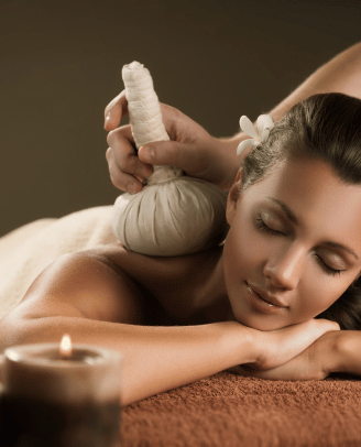 a woman getting a ayurvedic massage  at a spa