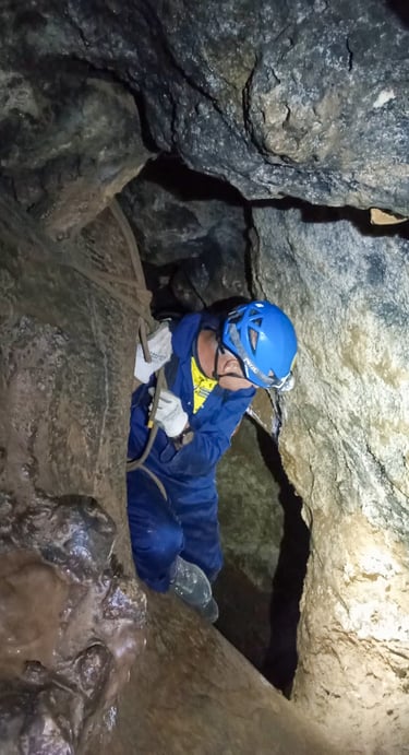 persona descendiendo por una cuerda en una cueva