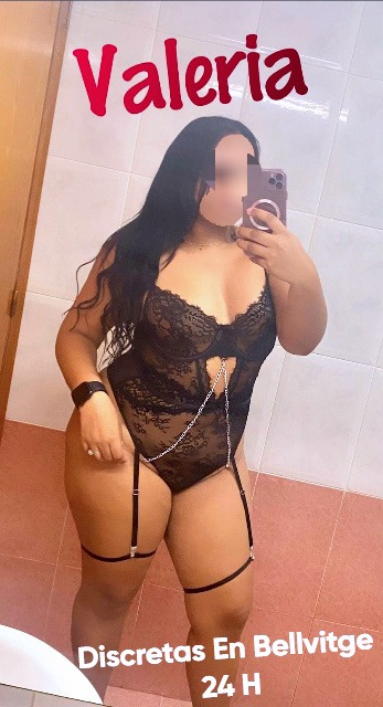 Valeria, escort latina con curvas, vestida en lencería negra con liguero, ofreciendo placer 24 horas en Bellvitge.