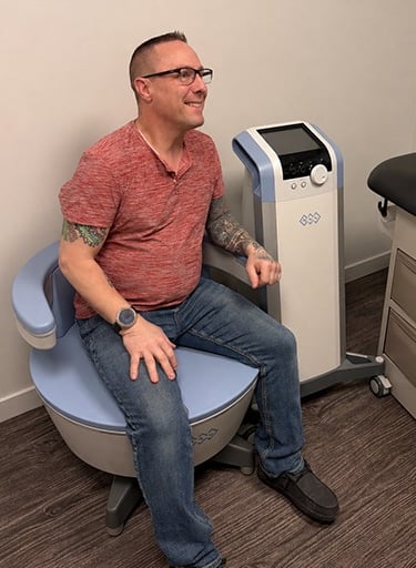 a man sitting on the BTL Emsella chair to strengthen pelvic muscles