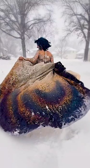 Bride running through a snow storm in a magical gold and blue wedding dress.