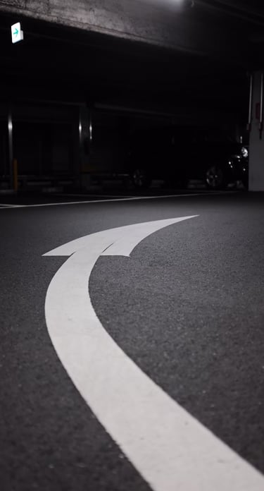 A figure of an arrow curving to the right, painted on the pavement.