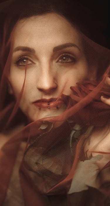 photo of a woman in a red dress with a veil on her head holding a rose