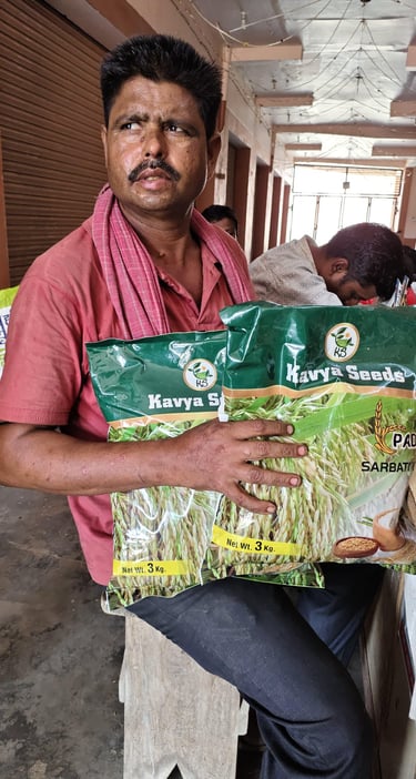 Indian farmer holding bags of Kavya Seeds Sarbati paddy rice in a local seed market.